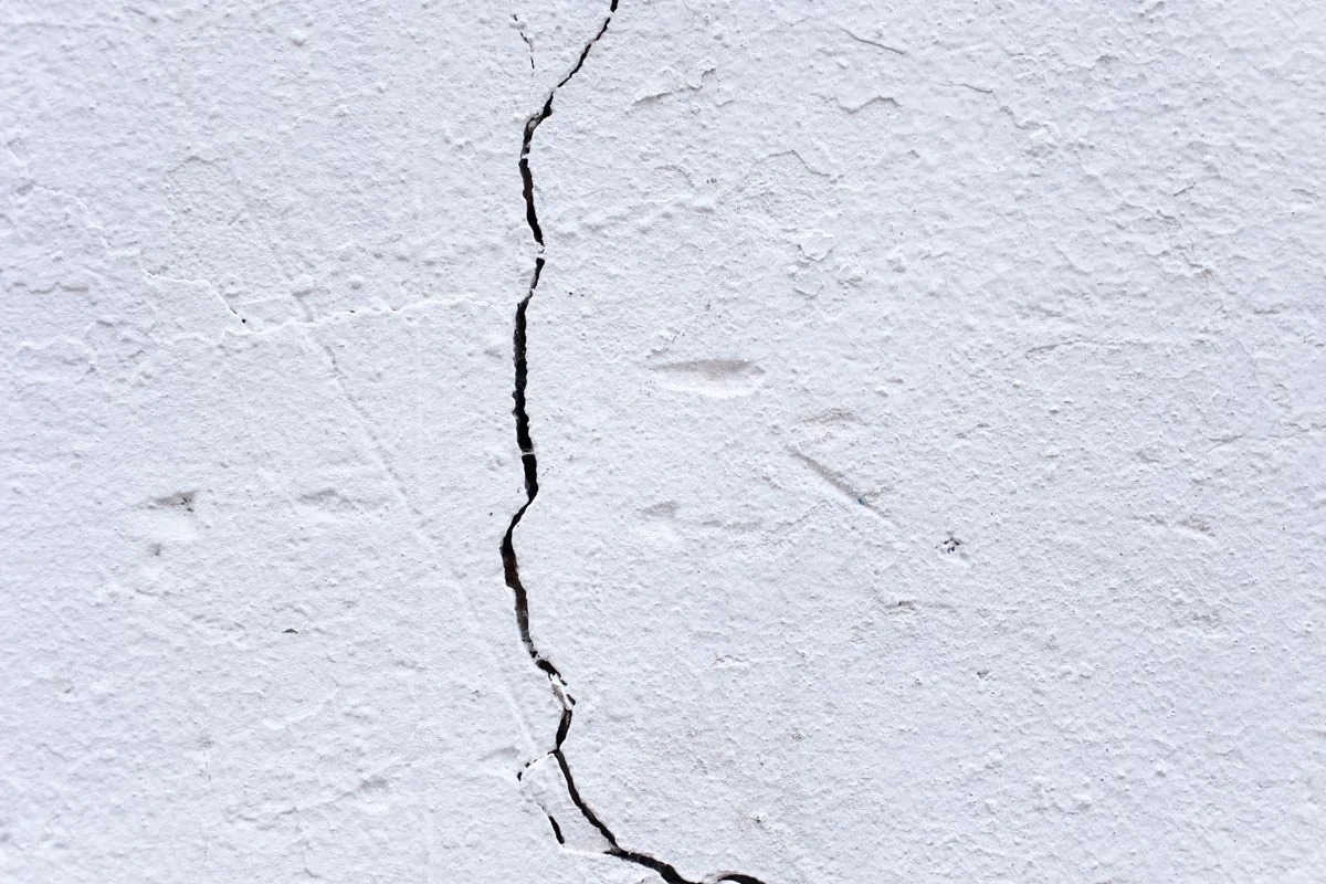Hairline crack in stucco wall requiring repair