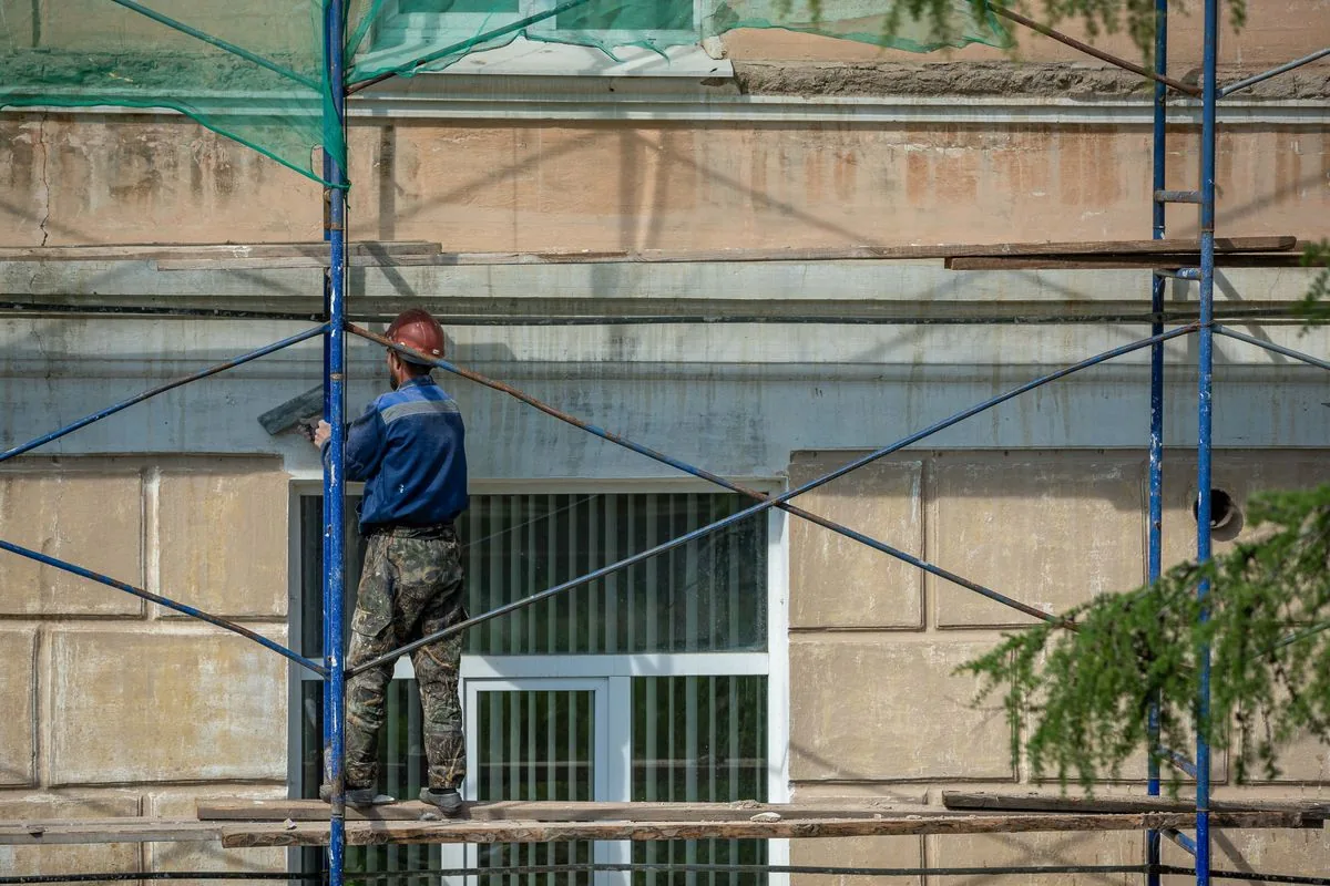 Stucco repair contractor on scaffolding in Tucson AZ